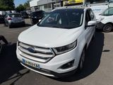 La Ford Edge blanche est garée sur un parking, à côté d'autres voitures.