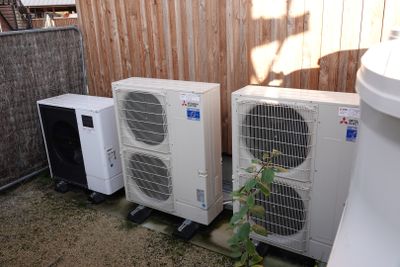 trois climatiseurs posés les uns à côté des autres sur le sol