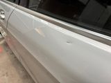 a white car with a broken door and a broken window