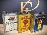 three cans of oil sitting on a table next to each other