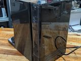 a black box sitting on a wooden table in front of a bookshelf