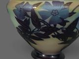 a vase with a blue flower on it on a table