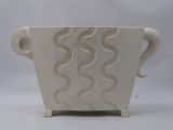 a white vase that has a handle on it