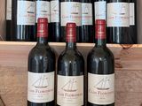 plusieurs bouteilles de vin rouge dans une caisse en bois posée sur un tonneau