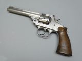 an old revolver with a wooden handle on a white surface