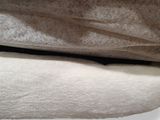 un chat allongé sur un lit, sous une couverture
