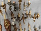 a lot of wall sconces that are hanging on the wall