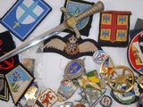 a lot of badges and a sword laying on a table