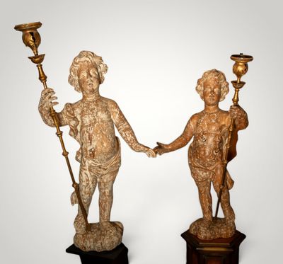 two statues of a boy and a girl holding hands on a pedestal