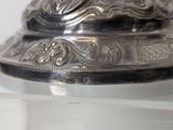 a close up of a silver plate on a shelf