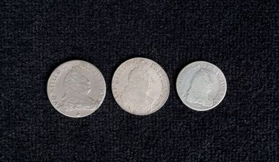 three different types of coins are shown on a black surface