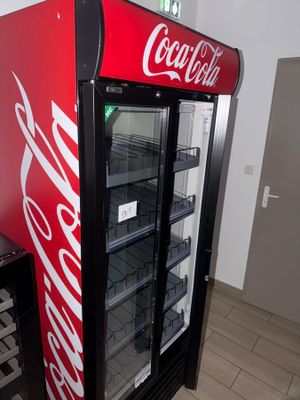 a coca cola machine in the corner of a room
