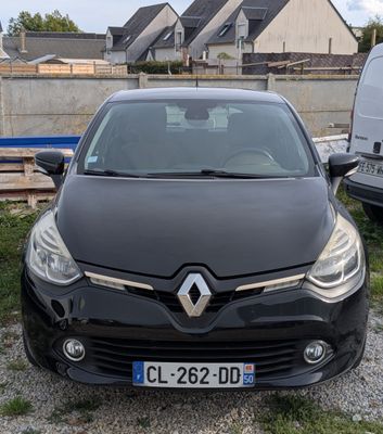 l'avant d'une voiture noire garée sur un parking à côté d'une camionnette blanche
