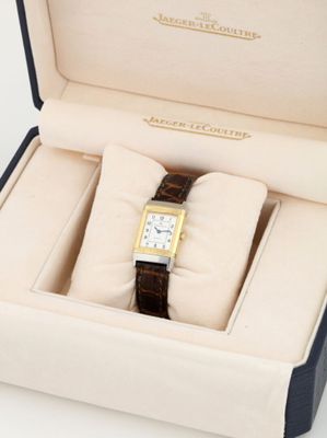 a box with a watch inside of it on a white surface