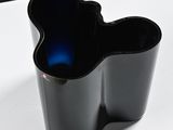 a black vase sitting on a table with a blue light in it
