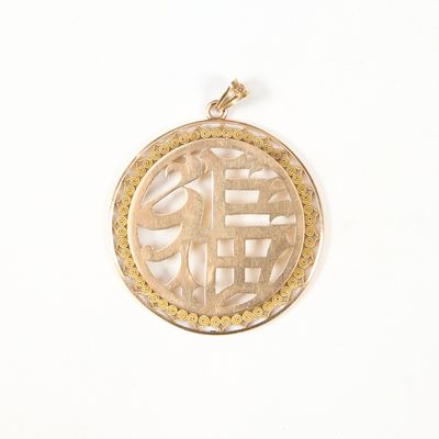 une image représentant un pendentif en or orné d'un symbole chinois