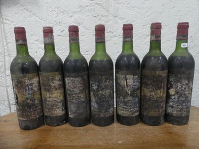 six bouteilles de vin posées sur une table devant un mur blanc