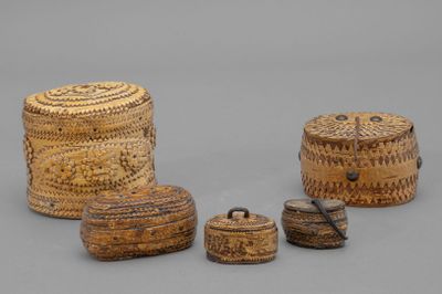 trois petites boîtes en osier avec couvercles et poignées, posées sur une surface grise