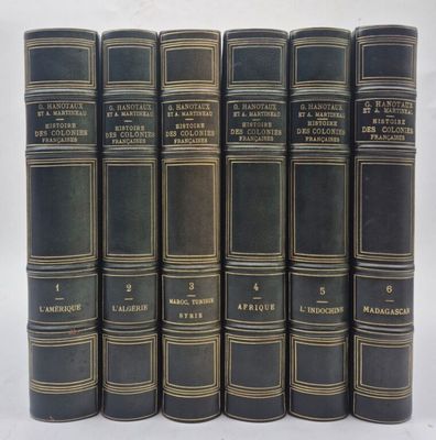 six vieux livres sont alignés sur une surface blanche
