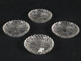 four clear glass bowls sitting on top of a black surface