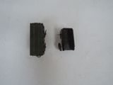 two pieces of black plastic on a white surface