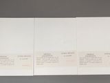 three white cards with pink writing on them sitting on a table