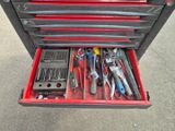 de nombreux outils dans une boîte à outils posée par terre