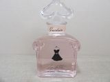 un flacon rose orné d'une robe noire