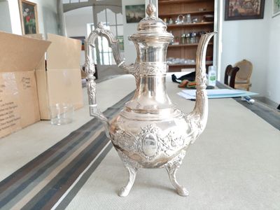 une théière en argent posée sur une table dans un salon