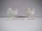 two white vases sitting on top of a white table