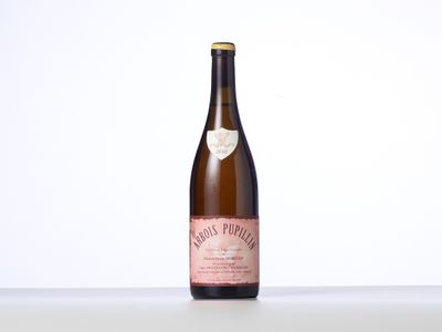 une bouteille de vin posée sur une table blanche