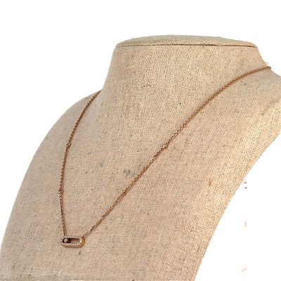 Le collier est posé sur le cou d'un mannequin, suspendu à une chaîne en or.