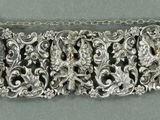 un gros plan d'un bracelet en argent posé sur une surface grise