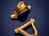 pair of gold plated brass hooks on a dark blue background