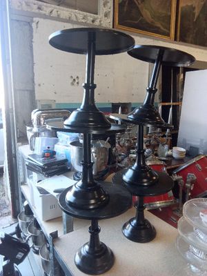 trois vases noirs posés sur une table dans une pièce