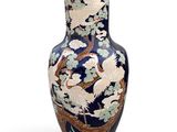 a blue vase with a bird and flowers on it