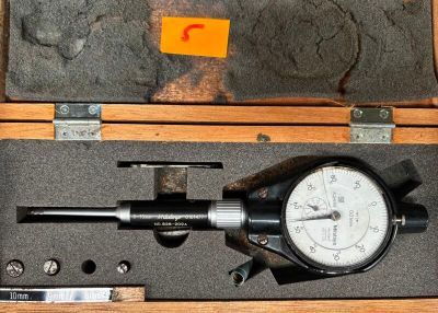 une photo d'un pied à coulisse dans un coffret en bois