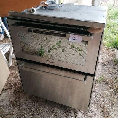 a silver oven that is sitting in the dirt
