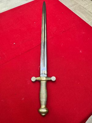 a close up of a sword on a red surface