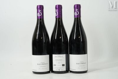 trois bouteilles de vin rouge sont posées sur une surface blanche