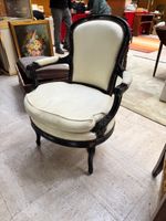 Fauteuil en bois noirci à dossier cintré, les consoles d’acc…