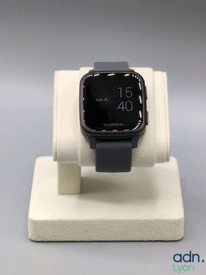 une Apple Watch noire posée sur un présentoir blanc