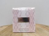 the box of the perfume is sitting on a wooden table