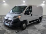 la camionnette blanche est garée dans une grande pièce au sol en damier