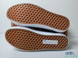 the bottom of a pair of white and brown shoes on a white surface