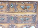a wooden chest of drawers with ornate carvings on it
