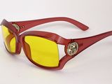 des lunettes de soleil rouges aux verres jaunes sur fond blanc