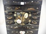 une commode noire ornée d'un motif d'oiseau