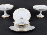 trois pièces en porcelaine blanche et dorée, ornées de bordures dorées