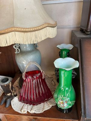une table sur laquelle se trouvent une lampe, des vases et d'autres objets